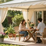 Freistehende Terrassenüberdachung mit gemütlichem Sitzbereich und blühenden Pflanzen.